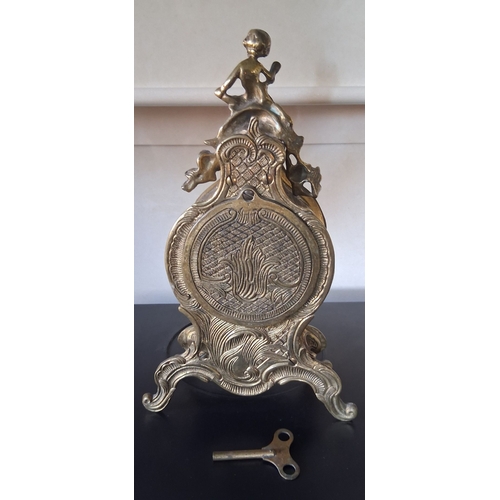 55 - A LOUIS XV STYLE BRASS FRANZ HERMLE MANTLE CLOCK, intricate piece with figural putti finial, raised ... 
