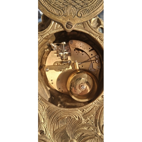 55 - A LOUIS XV STYLE BRASS FRANZ HERMLE MANTLE CLOCK, intricate piece with figural putti finial, raised ... 