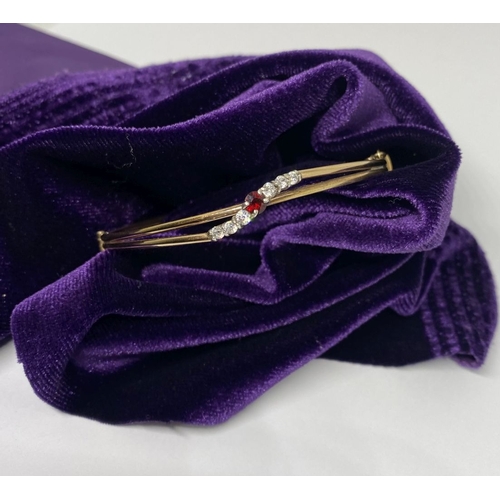 60 - A BEAUTIFUL GOLD GARNET BRACELET, with central round cut vibrant garnet flanked by six round cut cle... 