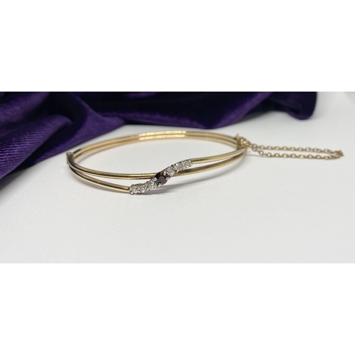 60 - A BEAUTIFUL GOLD GARNET BRACELET, with central round cut vibrant garnet flanked by six round cut cle... 