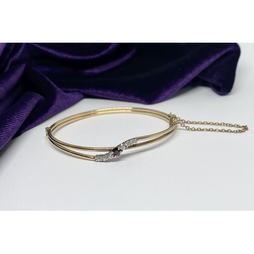 60 - A BEAUTIFUL GOLD GARNET BRACELET, with central round cut vibrant garnet flanked by six round cut cle... 