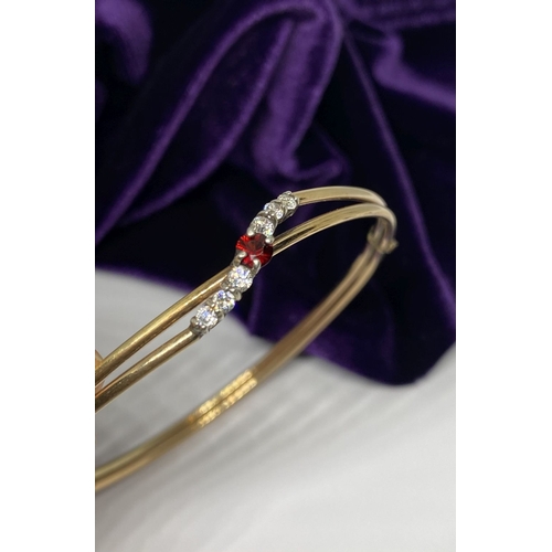 60 - A BEAUTIFUL GOLD GARNET BRACELET, with central round cut vibrant garnet flanked by six round cut cle... 