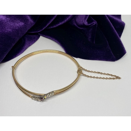 60 - A BEAUTIFUL GOLD GARNET BRACELET, with central round cut vibrant garnet flanked by six round cut cle... 