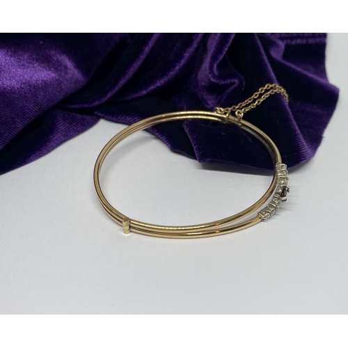 60 - A BEAUTIFUL GOLD GARNET BRACELET, with central round cut vibrant garnet flanked by six round cut cle... 