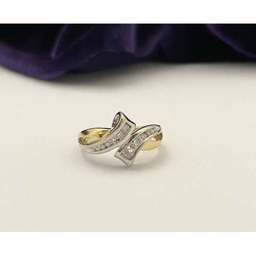 131 - A BEAUTIFUL TWO-TONE 14CT GOLD DIAMOND BYPASS RING, set with fourteen brilliant round cut diamonds, ... 