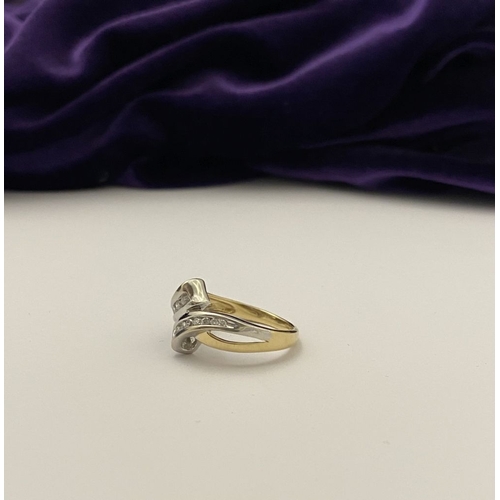 131 - A BEAUTIFUL TWO-TONE 14CT GOLD DIAMOND BYPASS RING, set with fourteen brilliant round cut diamonds, ... 