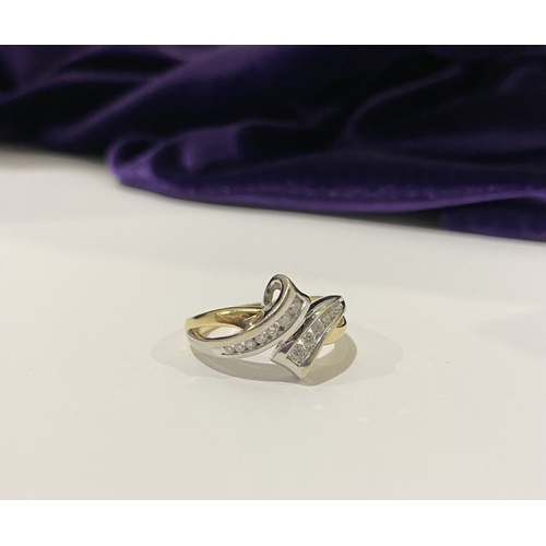 131 - A BEAUTIFUL TWO-TONE 14CT GOLD DIAMOND BYPASS RING, set with fourteen brilliant round cut diamonds, ... 