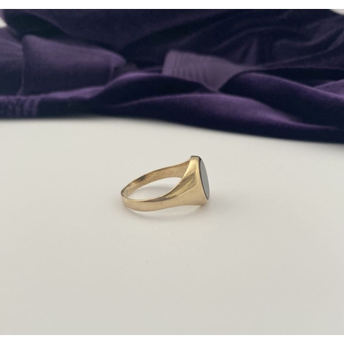 83 - AN IRISH 9CT GOLD GENTLEMAN'S ONYX SIGNET RING, featuring oval onyx in bezel setting, with tapered s... 