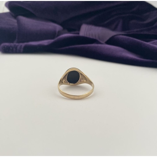 83 - AN IRISH 9CT GOLD GENTLEMAN'S ONYX SIGNET RING, featuring oval onyx in bezel setting, with tapered s... 