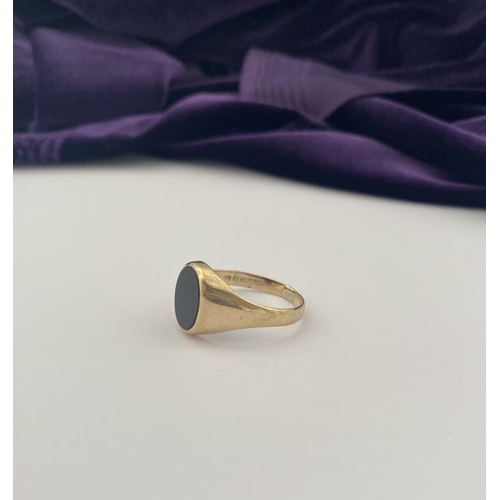 83 - AN IRISH 9CT GOLD GENTLEMAN'S ONYX SIGNET RING, featuring oval onyx in bezel setting, with tapered s... 