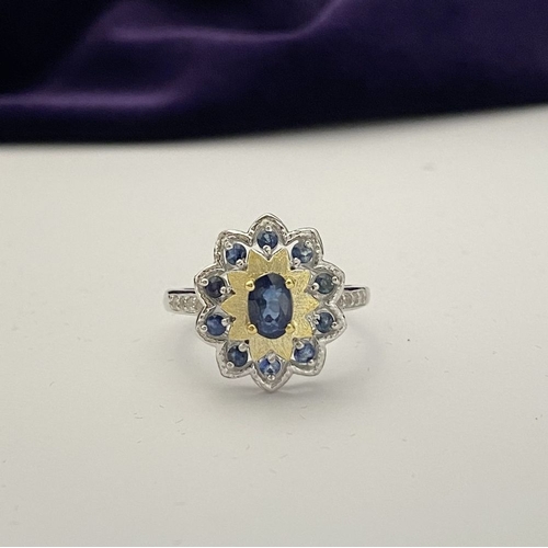30 - A BEAUTIFUL 18CT GOLD PLATED NATURAL SAPPHIRE CLUSTER RING, featuring central oval cut sapphire, sur... 