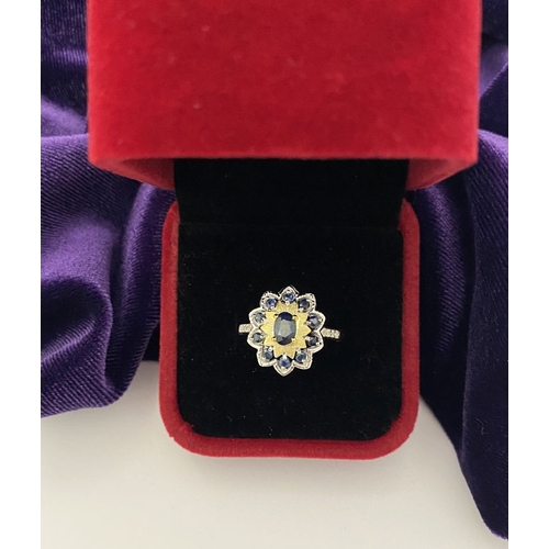 30 - A BEAUTIFUL 18CT GOLD PLATED NATURAL SAPPHIRE CLUSTER RING, featuring central oval cut sapphire, sur... 