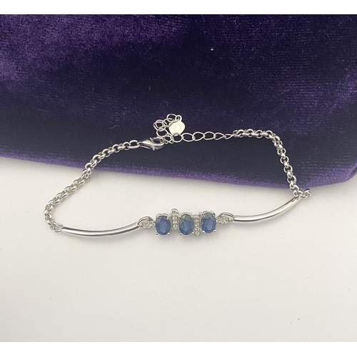 40 - A SPARKLING 18CT GOLD-PLATED SILVER THREE STONE SAPPHIRE BRACELET, featuring three oval cut vibrant ... 
