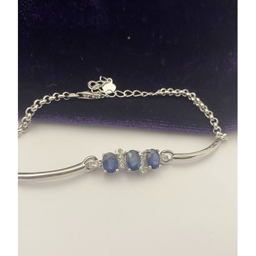 40 - A SPARKLING 18CT GOLD-PLATED SILVER THREE STONE SAPPHIRE BRACELET, featuring three oval cut vibrant ... 