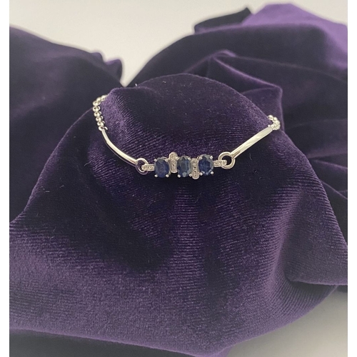 40 - A SPARKLING 18CT GOLD-PLATED SILVER THREE STONE SAPPHIRE BRACELET, featuring three oval cut vibrant ... 