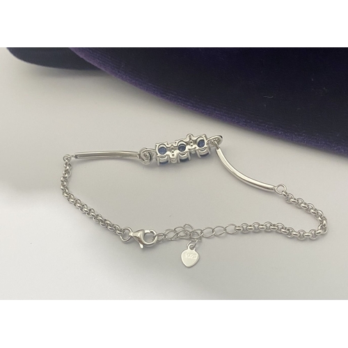 40 - A SPARKLING 18CT GOLD-PLATED SILVER THREE STONE SAPPHIRE BRACELET, featuring three oval cut vibrant ... 