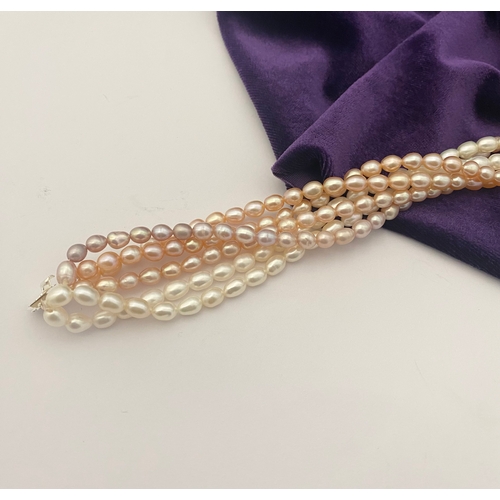 60 - A BEAUTIFUL SIX STRAND CULTURED PEARL NECKLACE, with silver clasp. Beautiful variety of tones to the... 
