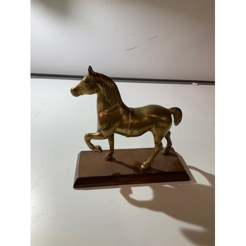 37 - Large brass horse on wooden plinth - spans just over 20cm