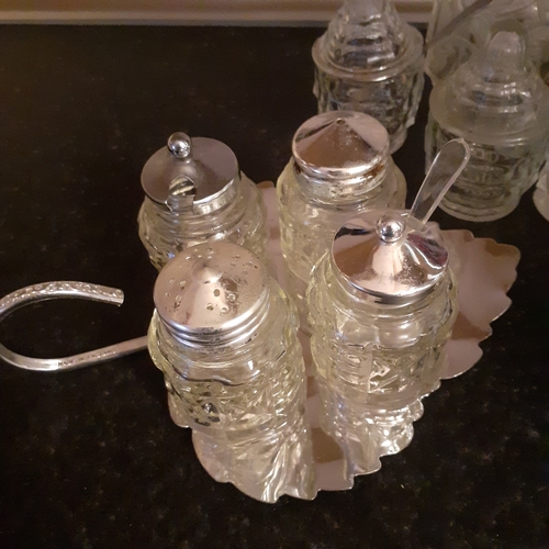 21 - Vintage and one possible antique glass cruet sets. One including silver spoon. Possibly silver lids ... 