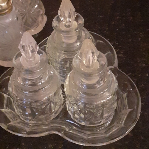 21 - Vintage and one possible antique glass cruet sets. One including silver spoon. Possibly silver lids ... 