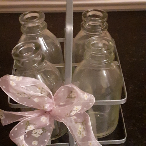 5 - 4 milk bottles in decorative metal holder.