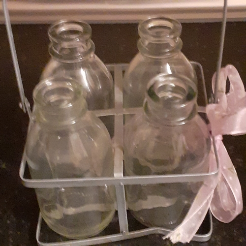 5 - 4 milk bottles in decorative metal holder.