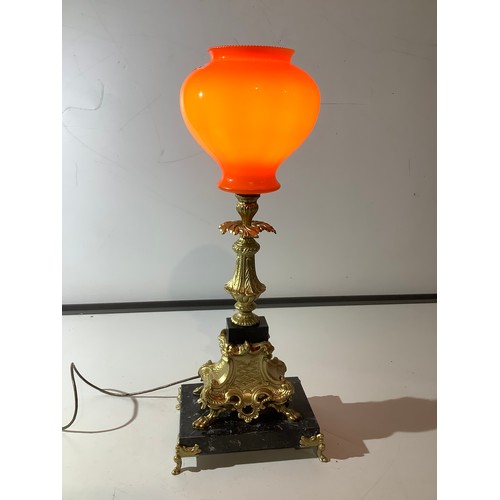 50 - Large ornate decorative heavy metal  lamp on marble plinth with gold feet and orange glass shade