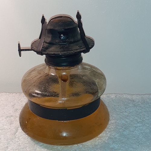 16 - An oil lamp glass tank. Black metal trims and top. The wick is in good clean condition. No damage to... 