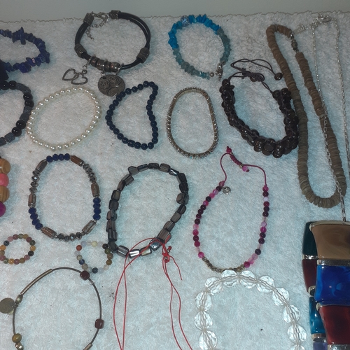 60 - A large quantity of beaded and stone bangles and a couple of necklaces. All complete with working cl... 