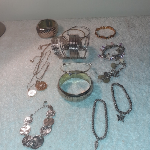 64 - A selection of metal bracelets and bangles. Some interesting coins and stones. All good condition