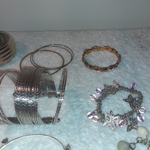 64 - A selection of metal bracelets and bangles. Some interesting coins and stones. All good condition