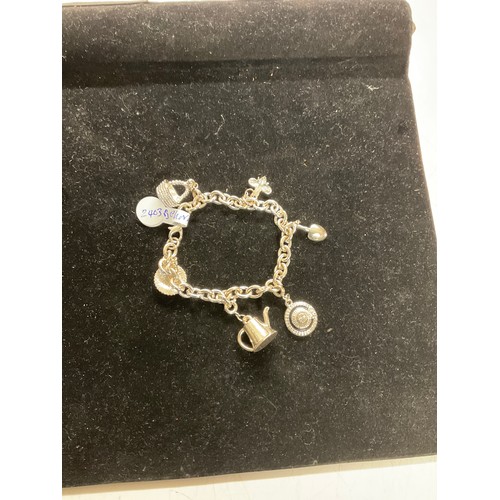 351 - silver coloured charm bracelet with charms attached