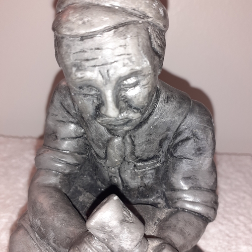 11 - Pewter ornament of old man sitting working.