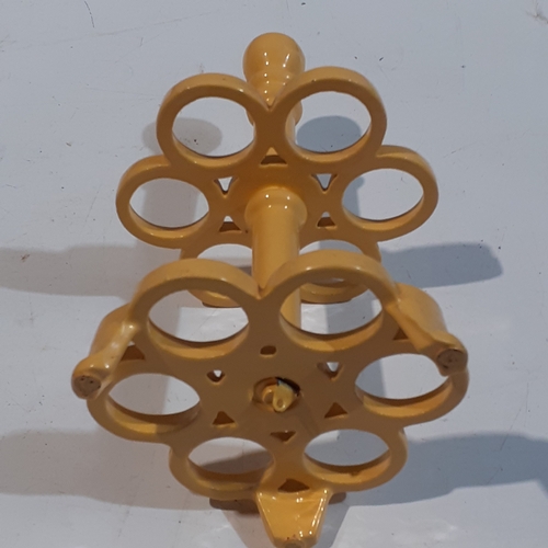 1 - Cast iron egg holder. Yellow, heavy and good condition.