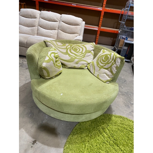 292 - Large green swivel cuddle chair with green circular under rug