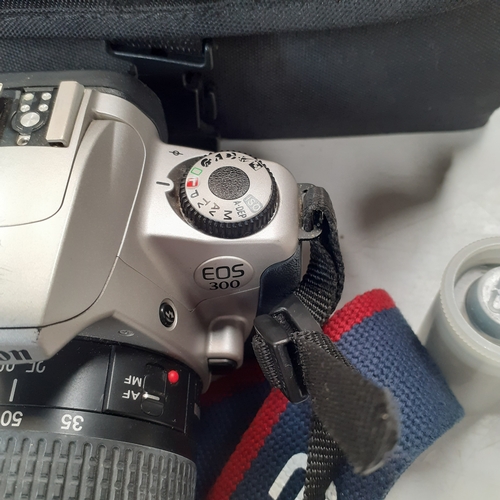 23 - Canon EOS 300 SLR camera with 35-80mm zoom lens and case. Some minor scratches on surface of camera ... 