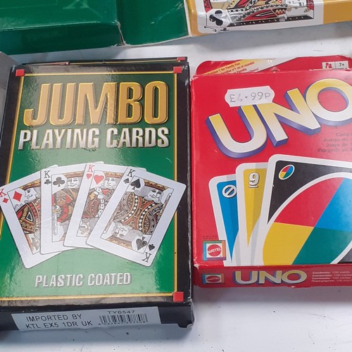 10 - A quantity of playing cards and related items. Includes Uno, giant cards, a compendium if card games... 