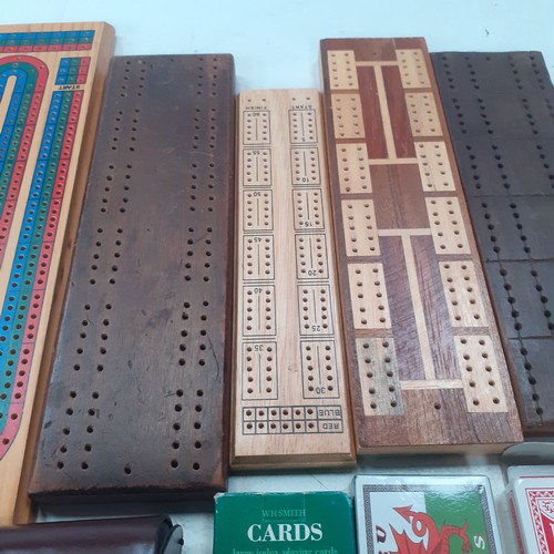 9 - 5 very  attractive cribbage boards with a sixth small cased one and 3 decks of playing cards. Some g... 