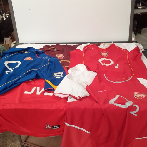 25 - A quantity of Arsenal shirts.  There is wear on the purple ones transfer 