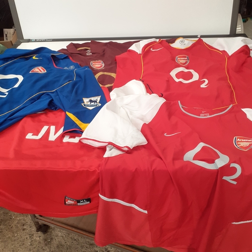 25 - A quantity of Arsenal shirts.  There is wear on the purple ones transfer 