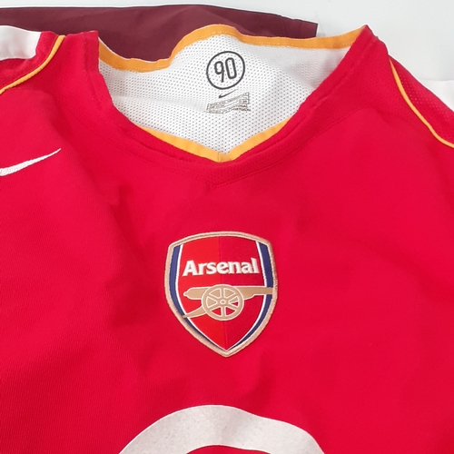 25 - A quantity of Arsenal shirts.  There is wear on the purple ones transfer 