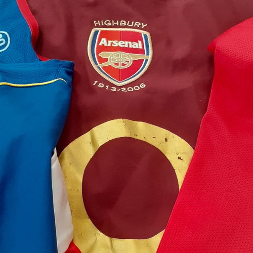 25 - A quantity of Arsenal shirts.  There is wear on the purple ones transfer 