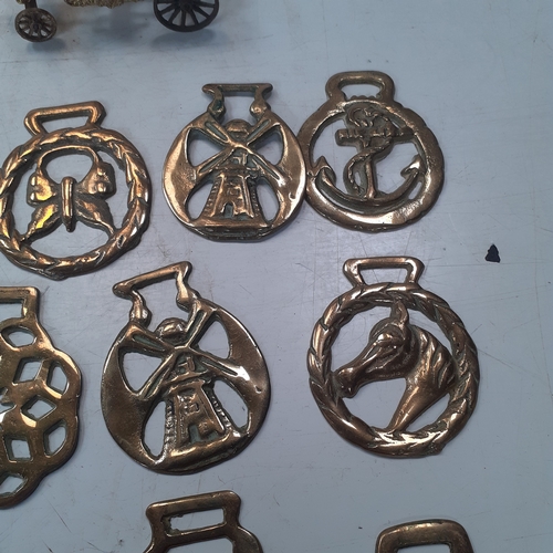 20 - Quantity of horse brasses with a small brass carraige. Unusual more rare brass depicting spiders web... 