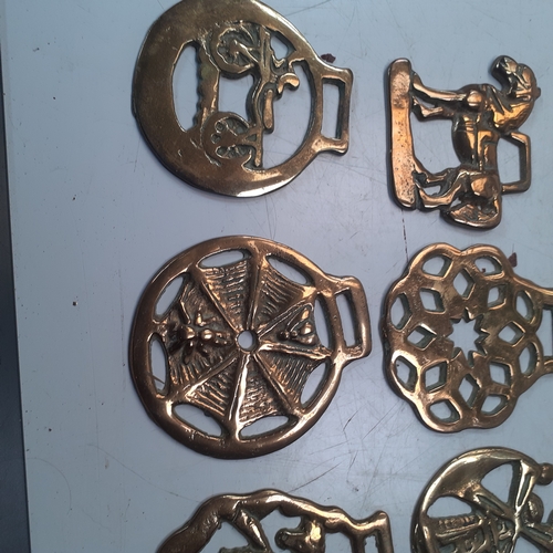 20 - Quantity of horse brasses with a small brass carraige. Unusual more rare brass depicting spiders web... 