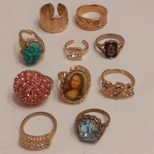 15 - A collection of gold coloured rings to include designs with Mona Lisa, a variety of coloured stones ... 