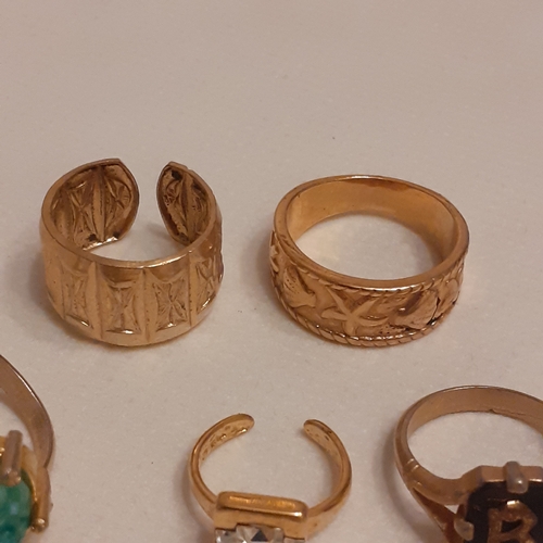 15 - A collection of gold coloured rings to include designs with Mona Lisa, a variety of coloured stones ... 