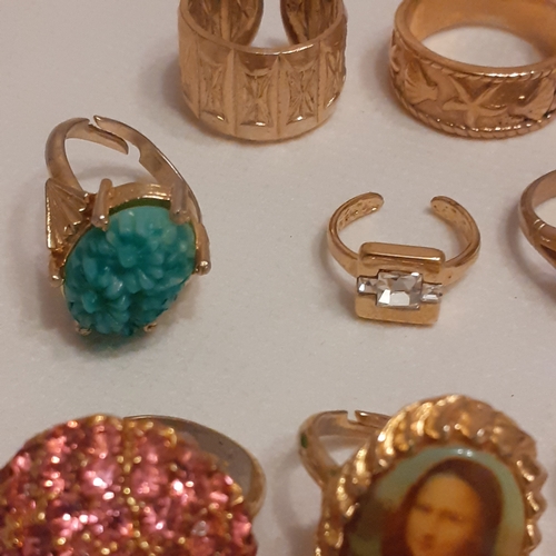 15 - A collection of gold coloured rings to include designs with Mona Lisa, a variety of coloured stones ... 