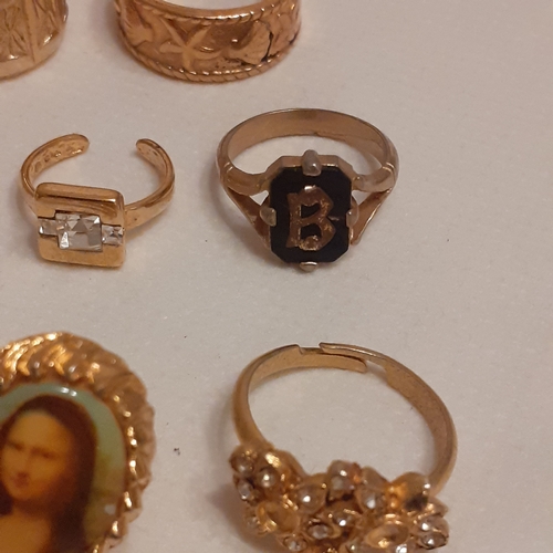 15 - A collection of gold coloured rings to include designs with Mona Lisa, a variety of coloured stones ... 