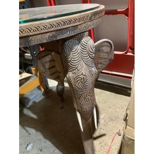 291 - African style carved circular coffee top with trio of elephant heads as legs