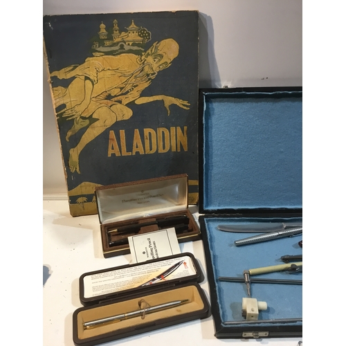 298 - Case of compasses & pens as well Parker & other pens and a vintage Aladdin book